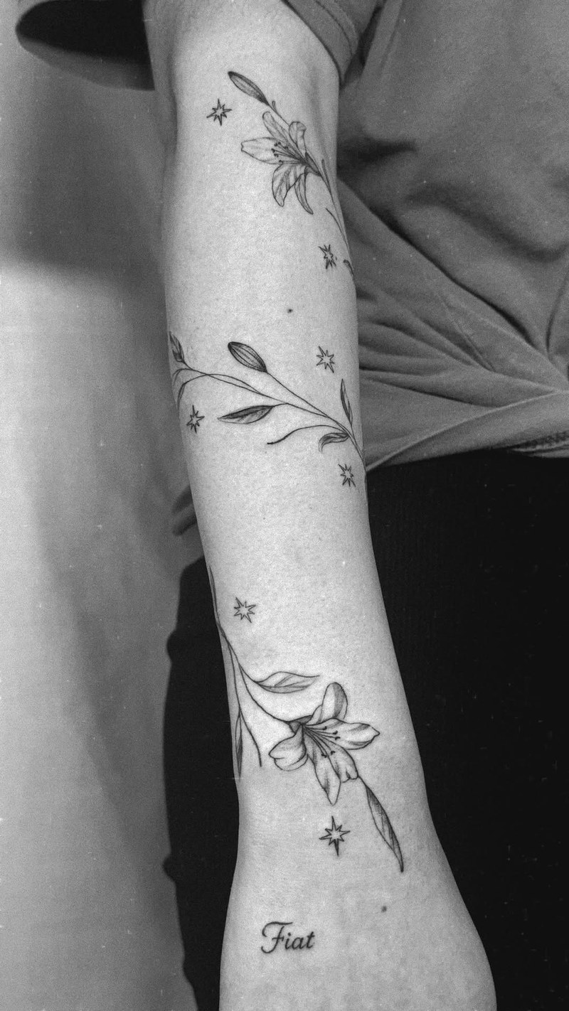 Lilies woven into a vine that flows with the body, surrounded by 12 stars in hon